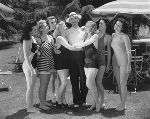 Hollywood, Kalifornien: ca. 1935 Sieben junge Frauen in Badeanzügen wetteifern um die Aufmerksamkeit eines einzelnen Mannes. (s/w Foto) von Unbekannt