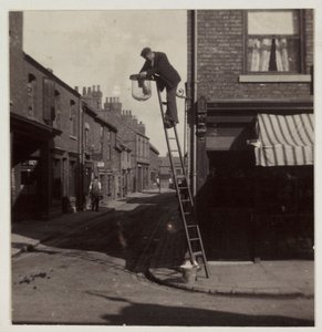 Mann reinigt eine Gaslaterne, um 1905 von Unbekannt