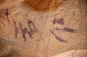Felskunst, Vorgeschichte: Felsmalerei einer Gruppe von Figuren und „Guerbas“ (Wasserschläuche) mit und ohne Fransen in einem verzierten Schutzraum, im Uweinat-Massiv, Sudan (8000 bis 3000 v. Chr.)