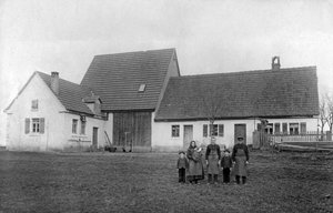 Bauernfamilie posiert vor dem Bauernhof. von Unbekannt