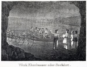 Salzmine: eine Gruppe von Besuchern überquert den unterirdischen Salzsee der Mine auf einem Boot, in Durrnberg, Österreich