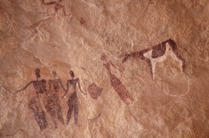 Felskunst, Vorgeschichte: Felsmalerei einer Gruppe von Figuren und einer zweifarbigen Kuh mit großen Hörnern in einem verzierten Schutzraum im Uweinat-Massiv, Ägypten. (Zeitraum von 8000 bis 3000 v. Chr.). Fotografie