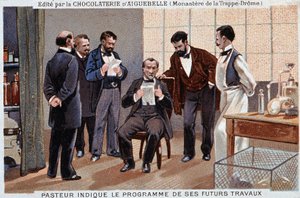 Louis Pasteur, ein französischer Wissenschaftler, zeigt das Programm seiner zukünftigen Arbeit, umgeben von Mitarbeitern - Schokoladenwerbung von Aiguebelle