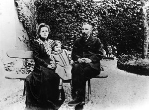 Pierre (1859-1906) und Marie Curie (1867-1934) sitzen auf einer Bank in einem Garten