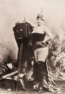 Porträt einer teilweise nackten Frau, die sich auf eine antike Kamera lehnt von Unknown photographer