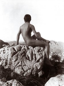 Junger Mann auf einem Felsen posierend