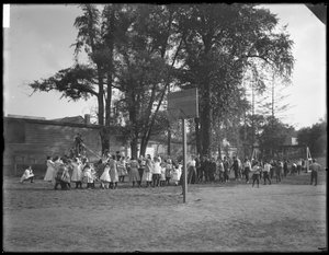Jungen und Mädchen spielen Tauziehen auf einem unbekannten Spielplatz, ca. 1910