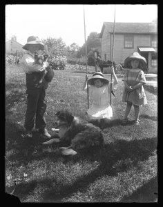 Kinder mit einem Hund und einem Welpen versammeln sich um eine Seilschaukel auf der McCready-Farm, Pennsylvania, ca. 1913