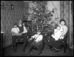Informelles Gruppenporträt einer unbekannten Familie in ihrer Wohnung vor einem Weihnachtsbaum, New York City, ca. 1915-16 von William Davis Hassler