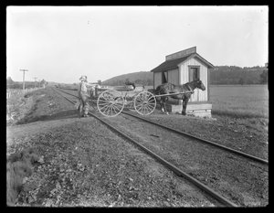 Unbekannter Mann lädt Milch auf einen pferdegezogenen Wagen, der über Eisenbahnschienen vor der McCready-Farm in Pennsylvania parkt, ca. 1913 von William Davis Hassler