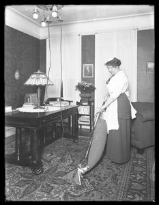 Unbekannte Frau demonstriert die Verwendung des Apex-Staubsaugers, ca. 1913-14