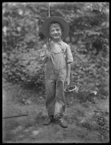 William Gray Hassler mit Strohhut und Latzhose, trägt Angelrute und Korb im Wald, 20. August 1911 von William Davis Hassler