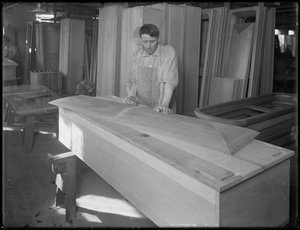 Arbeiter passt ein Stück eines Sargdeckels an, Oneida, New York, 3. April 1916 von William Davis Hassler