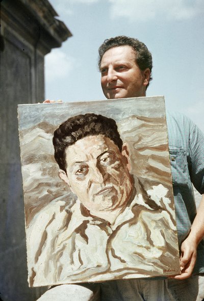 Der italienische Maler und Schriftsteller Carlo Levi (1902-1975) hält eines seiner Werke, ein Porträt des Gewerkschafters Giuseppe di Vittorio von Ando Gilardi
