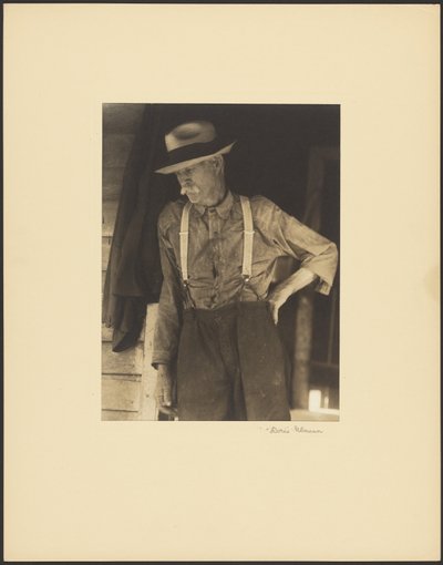 [Bärtiger alter Mann mit Strohhut und Hosenträgern in Tür stehend] von Doris Ulmann