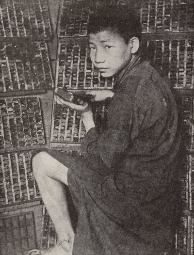 Chinesischer Junge beim Setzen von Typen von English Photographer