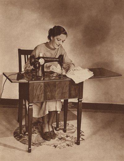 Hausfrau bei der Arbeit an der Nähmaschine, Mitte der 1930er Jahre von English Photographer