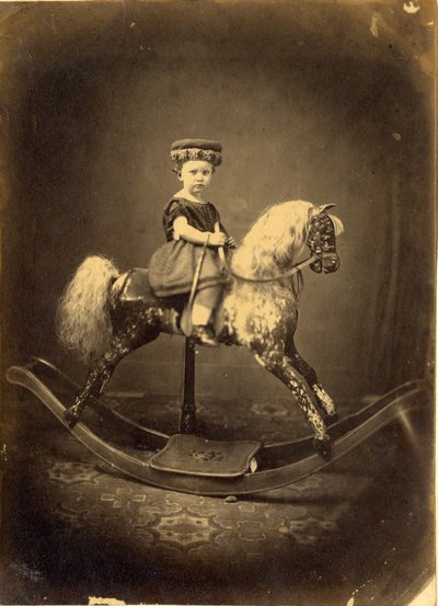 Junges Mädchen auf einem gesprenkelten Schaukelpferd von English Photographer