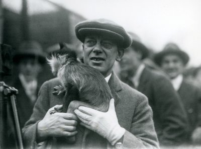Ein Schwarzhauben-Mangabe, möglicherweise Freckles, mit seinem Betreuer, nimmt an einer Außenübertragung aus dem London Zoo teil, 1925 von Frederick William Bond
