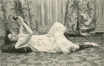 Mädchen, das auf dem Boden liegt und einen Ball über dem Kopf hält von French Photographer