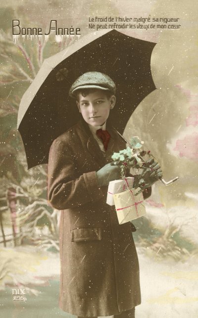 Hübscher, gut gekleideter Junge, der im Schnee mit einem Regenschirm steht von French Photographer