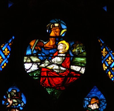 Das westliche Rosenfenster zeigt eine Szene aus dem Buch der Offenbarung: Öffnung des dritten Siegels, mit dem Stier des Lukas (6:5). von French School