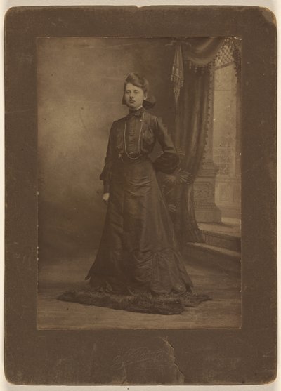 Porträt einer jungen Frau im langen schwarzen Kleid, stehend von George W. Killian