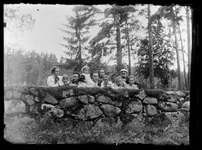 Hugo Simberg mit Geschwistern auf einer Steinmauer von Hugo Simberg