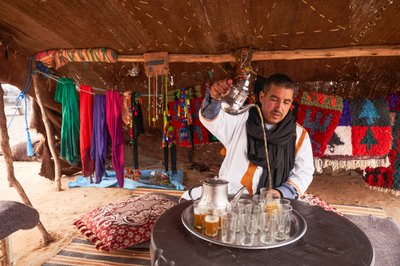 Ein Einheimischer serviert Minztee in Erg Chebbi in der Wüste nahe Merzouga, Marokko, 2019 (Foto) von Ira Block