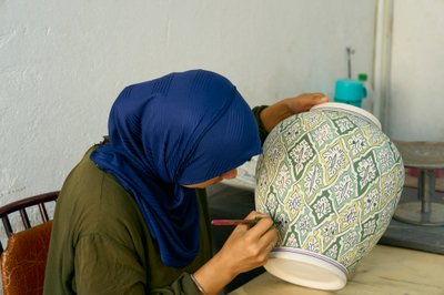 Frau bei der Arbeit in einer Keramikfabrik in Fes, Marokko, 2022 (Foto) von Ira Block