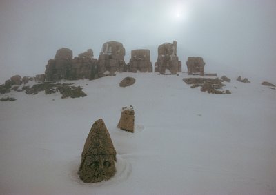 Statue eines Gottes ragt über eine Schneedecke am Nemrud Dagh. Nemrud Dagh, Türkei. von James L Stanfield