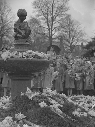 Kinder legen Narzissensträuße auf einen Brunnen mit Statue oben von Joseph Hardman