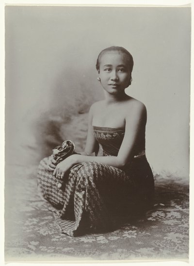 Studio-Porträt einer sitzenden jungen javanischen Frau in einem Sarong mit Batik-Muster von Kassian Cephas