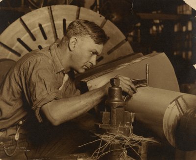 Mann mit Mikrometer, der eine Welle auf Tausendstel eines Zolls misst von Lewis W. Hine