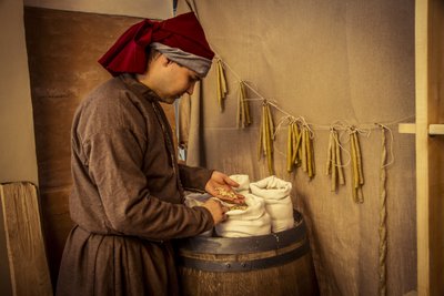 Historische Nachstellung: Kerzen und Säcke mit Weizen, Roggen und Gerste in der Apotheke von Diotaiuti, Imola, Italien, Mitte des 14. Jahrhunderts von Unbekannt Unbekannt