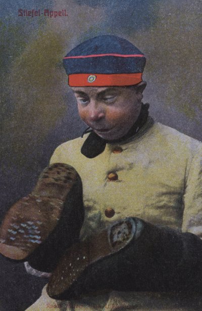 Deutscher Soldat betrachtet die Sohlen seiner Stiefel von Photographer German