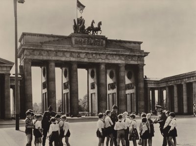 Junge Pioniere kommen zum Brandenburger Tor, dem Wahrzeichen Berlins, um ihre Freunde, die Grenzschutztruppen, zu sehen (s/w Foto) von Photographer German