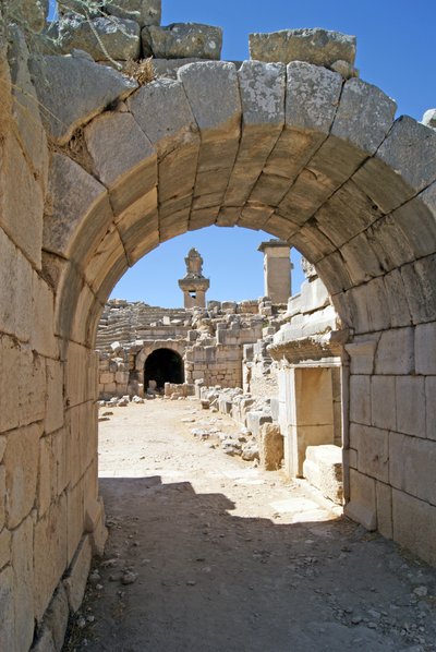 Blick durch den gewölbten Eingang des Theaters von Xanthos in die Orchestergrube, mit Säule und Harpyiengrab, Xanthos, Türkei von Roman