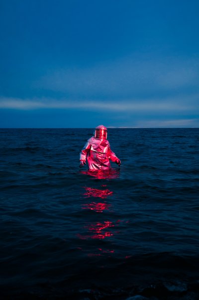 Roter Anzug Blaues Meer von Samantha Hearn