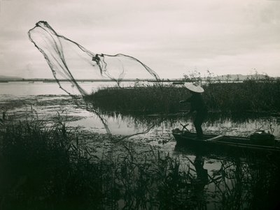 Japanischer Fischer wirft seine Netze auf einem See aus, um 1900 - 1915 von Teijiro Takagi