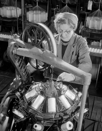Eine mittelalte Arbeiterin, die Kabelspulen flechtet, Johnson und Phillips von Unbekannt