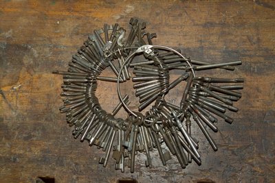 Großes Bündel alter Schlüssel auf Ring auf Holzschreibtisch von Unbekannt