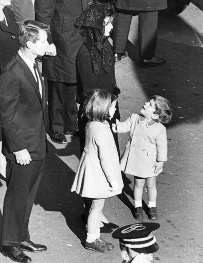 Kleiner John Kennedy schaut zu seiner Mutter auf, als ob er sagen würde: 
