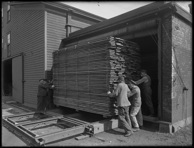 Entfernen von Holz, das für die Herstellung von Särgen verwendet werden soll, aus dem Trockenofen, Oneida, New York, 3. April 1916 von William Davis Hassler