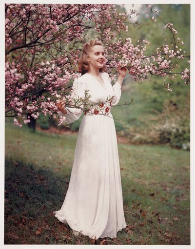 Frau, die ein Kleid in der Nähe von Blüten modelliert, ca. 1940er von Frederick (attr. to) Barnard