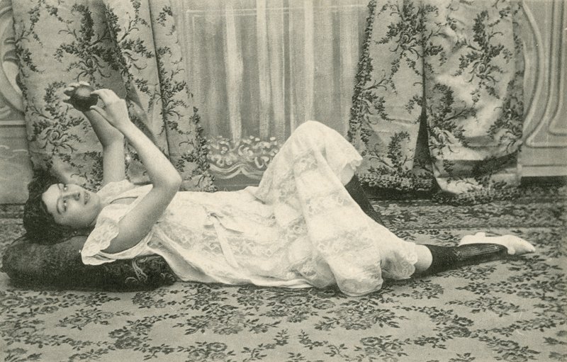 Mädchen, das auf dem Boden liegt und einen Ball über dem Kopf hält von French Photographer