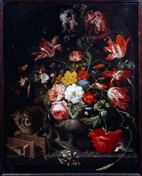 Katze, die eine Blumenvase umstößt.