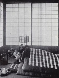 Mädchen schläft zwischen wattierten Decken mit einem Holzkissen