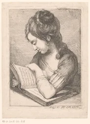 Lesende junge Frau an einem Tisch, ihr Ellbogen auf einem Buch ruhend