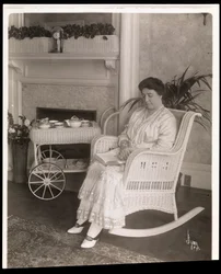 Mrs. Howard sitzt mit einem Buch in einem Schaukelstuhl in ihrem Haus in der 5th Avenue 200, New York, 1915-6